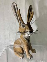 Front view of hand-carved and painted jackalope decoy showing detailed face, ears, and wire whiskers.