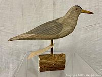 Side view of the wooden tern decoy showing detailed painting and natural wood base.