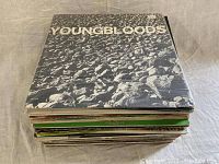 Stack of 40 vinyl records with Youngbloods album on top, showing cover artwork of crowd in black and white.