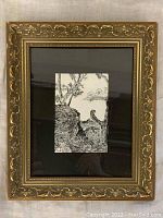 Full view showing the framed pen and ink drawing with ornate gold frame and black matte.