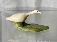 Front view of white goose carving on green stone base