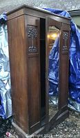 Full front and side view of large antique mahogany Edwardian wardrobe, showing dark wood finish and carved panels.