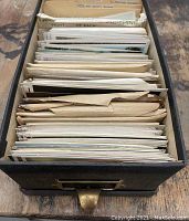 Oilskin file box filled with postcards organized by dividers