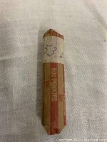 Photo of a rolled coin wrapper labeled 53 D reflecting the contents as 1953D wheat pennies.