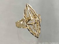 Front angled view of the 14K gold filigree ring showing the elongated marquise shaped filigree design and intricate openwork detail.