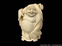 Frontal view of carved Buddha figurine showing detailed facial features, exposed rounded belly and traditional robes.