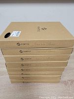 Stack of six brown cardboard boxes labeled 'Fintie Dare to be Different', each containing a keyboard case for Samsung tablets.