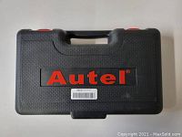Closed black hard case with red Autel logo and handle seen from front.