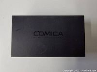 Black box with COMICA branding on lid, closed