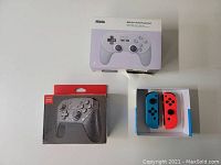 Overview of three controllers: 8BitDo SN30 Pro+ new in box, Nintendo Switch wireless controller open box, and Singland Joy-Con style controllers box.