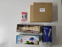 Top view showing boxed AIBOO LED under cabinet lighting, ZEEKEER vacuum sealer, electric milk frother box, and a small packaged baby safety lock.