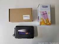 Three boxes/packages including plain cardboard box, white portable juicer box with pink juicer image, and black Pixton hard case with logo