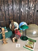 Photo showing multiple bird feeder items including green metal squirrel proof feeder, decorative bird houses, thermometers, and plastic dome.