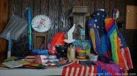 Full view of all items on table including wooden birdhouse, shovel, flags, fountain, and garden supplies