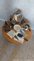 Full view of lot on small round table showing steam pot, electric skillet, assorted utensils, pastry bags, glass bottles, and gravy boat.