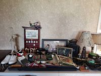 Wide view of lot showing golf shoes, balls, club covers, figurines and golf decor including clock and signs.