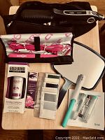 Full view of Croc titanium flat iron in case, Croc mini flat iron, hand mirror, Gold Bond beauty cream, mascara, Quip toothbrush and accessories, and fabric color swatches