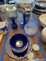 Overview of lot with bowls, vase, large glass goblet with corks, plate, lamp finials, and ceramic mug.