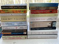 Photo of two stacks of paperback books, showing titles and authors clearly for identification.