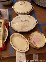 Photo showing two covered Limoges serving dishes, oval Johnson Brothers dish, vintage Royal Bavaria saucers.