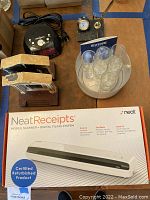 Neat Receipts mobile scanner in original box with other lot items on table