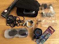 Full view of flashlight, step counter, earbuds, glucose tester, sunglasses, toothbrush head and blood pressure monitor with case.