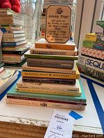 Photo shows a stack of yoga and meditation books as well as a Serenity Prayer plaque on a windowsill.
