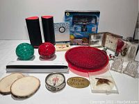 Full lot composition showing 2 wireless speakers, 2 glass paperweights, vintage tire gauge, brass airplane tag, scanner, glass tray and decorative items