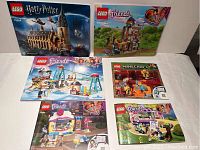 Photo of LEGO Harry Potter Hogwarts Castle boxed set with five other LEGO sets boxed or bagged from Friends and Minecraft series.