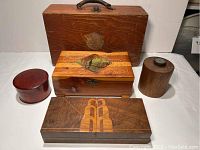 All five vintage wooden boxes arranged with the large wooden box with handle behind the smaller boxes