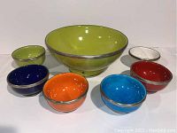 Overview of all 7 pottery bowls showing colors and metal trim.
