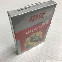 Front angled view of the sealed Atari 2600 Galaxian game box with visible Zeller's store price tags on the front plastic wrap.