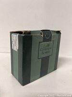 Box for jewelry holder showing La Compagnie Bombay label and green stripes.