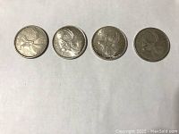 Four Canadian quarters arranged in a row showing the caribou reverse design.