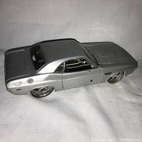 Left rear angled view of the silver metal die cast 1970 Dodge Challenger model showing black roof, wheels, and side details.