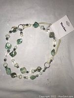 Front view of the double strand Tan Jay necklace showing beads and original price tag $22.