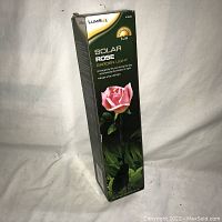 Boxed Lumisol Solar Rose Garden Light showing front and side views of packaging with product image and details.