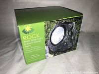 Photo of the product box showing the brand Rock and product image of rock-shaped solar light.