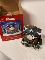 Image of the clock with its red Sears box showing the product name and design.