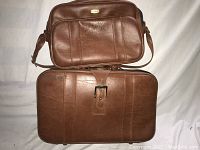 Two-piece Jet Stream brown luggage set showing larger suitcase with buckle and smaller shoulder bag.