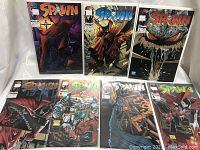 Full set of Spawn comics issues 2 to 8 displayed in protective sleeves.