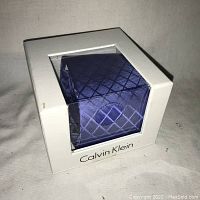 Calvin Klein men's necktie inside the original white box with transparent window. Box is marked with Calvin Klein logo.