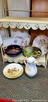 Overview showing all items on shelf with visible floral and scenic designs.