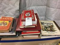 Pile of varied cookbooks including Elsie's Cook Book and The Book of Yogurt, stacked showing front covers and spines of various books.