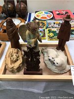 Tray with various wooden and stone carved figures including religious themed and folk art figures