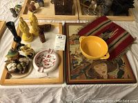 View showing variety of items including yellow Fiestaware bowl, Asian figurines in yellow glaze, artwork, ceramic pitcher and ashtray.