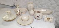Overall collection of Lenox porcelain decorative items including 3 bowls, 4 vases, and 1 clock arranged on white surface