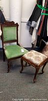 Full view of the vintage Eastlake style chair with green upholstery and accompanying upholstered footstool.