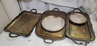 Four vintage silver plated footed trays displayed together showing tarnishing and varying sizes.