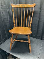 Full view of Hitchcock wooden chair showing spindled back, turned legs and stretchers, and sculpted seat.